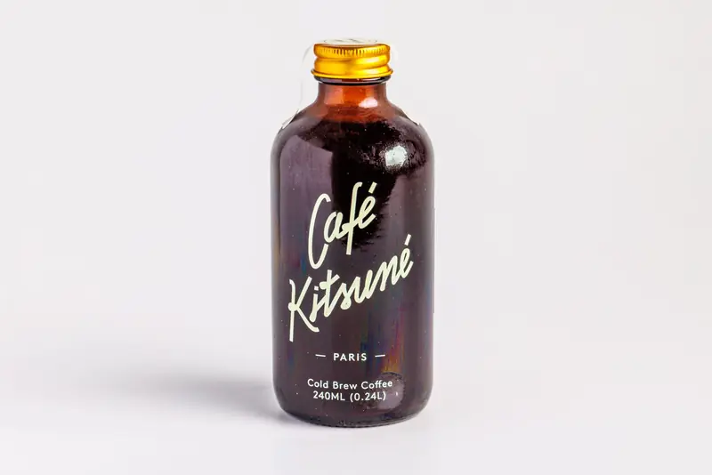 A minimalistic shot of Café Kitsuné cold brew coffee bottle with white backdrop
