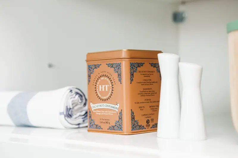 Modern kitchen shelf with tea container, spices, and rolled towel for a fresh look