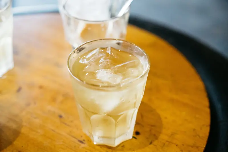 Close-up of refreshing iced tea in a glass with ice cubes on a wooden table