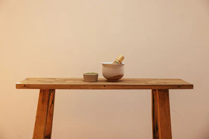 Minimalist setup with matcha bowl and whisk on rustic wooden table, ideal for tea enthusiasts