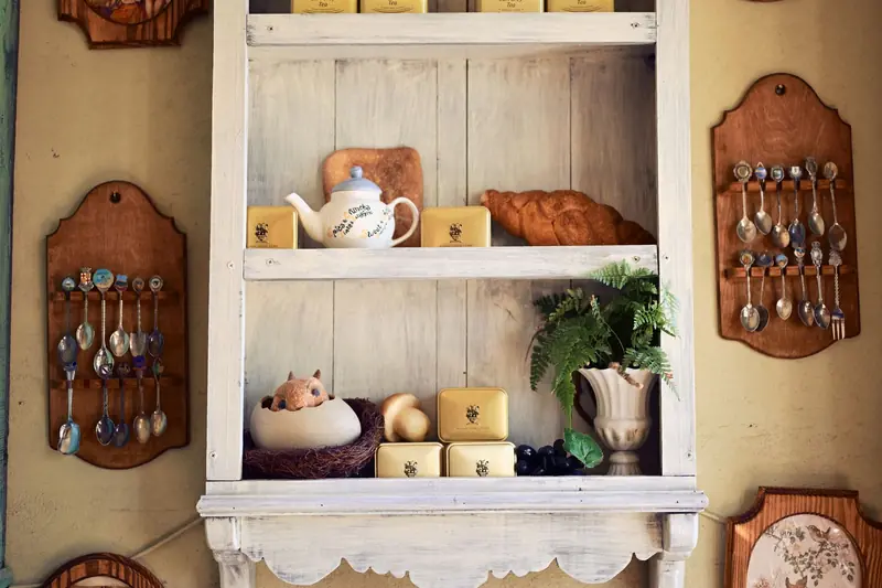 Charming vintage kitchen shelf with teapot, tins, and decorative spoons for a cozy and nostalgic kitchen vibe