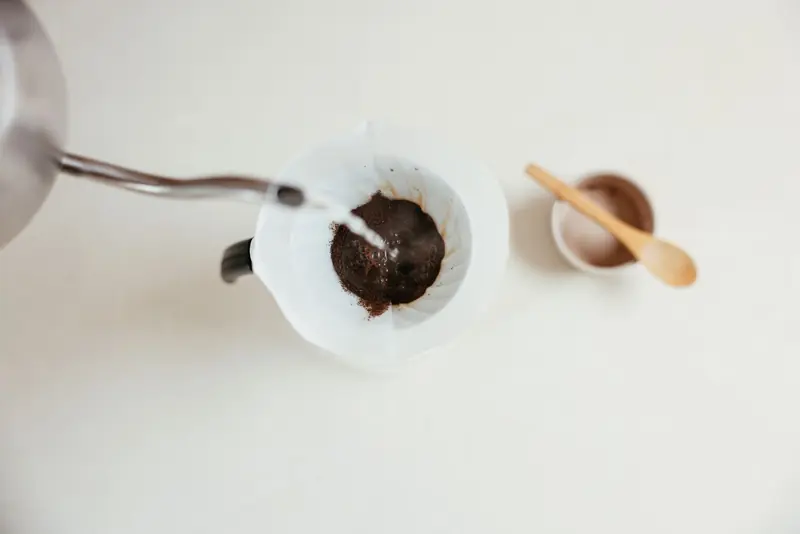 A close-up shot of pour over coffee brewing with a gooseneck kettle and filter